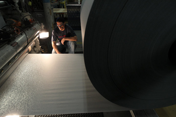 Ryan Isherwood inspects the quality of the paper inside Onyx Specialty Papers in Lee, Massachusetts.