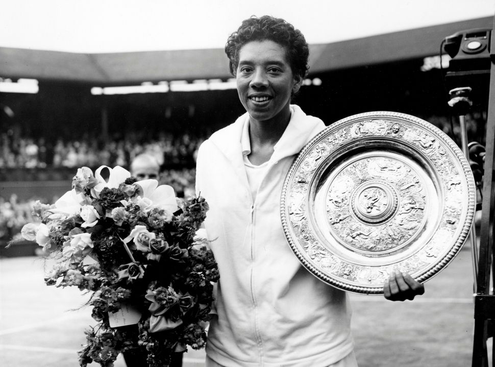 Althea Gibson holds her trophy after winning at Wimbledon on July 5, 1958.
