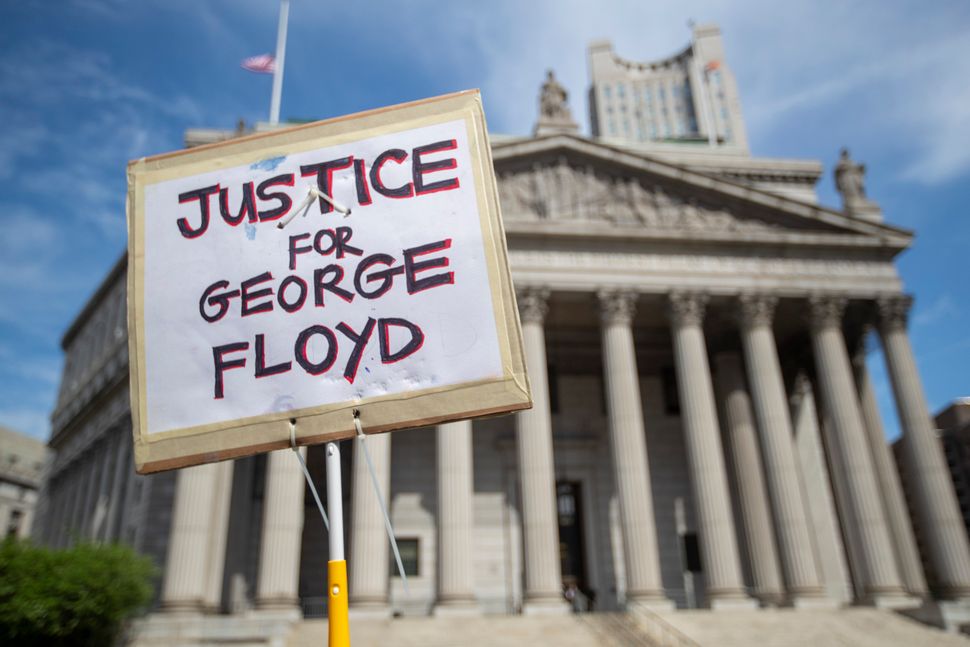A protester holds a sign in front of New York Supreme Court on May 29 demanding justice for George Floyd, a handcuffed black 