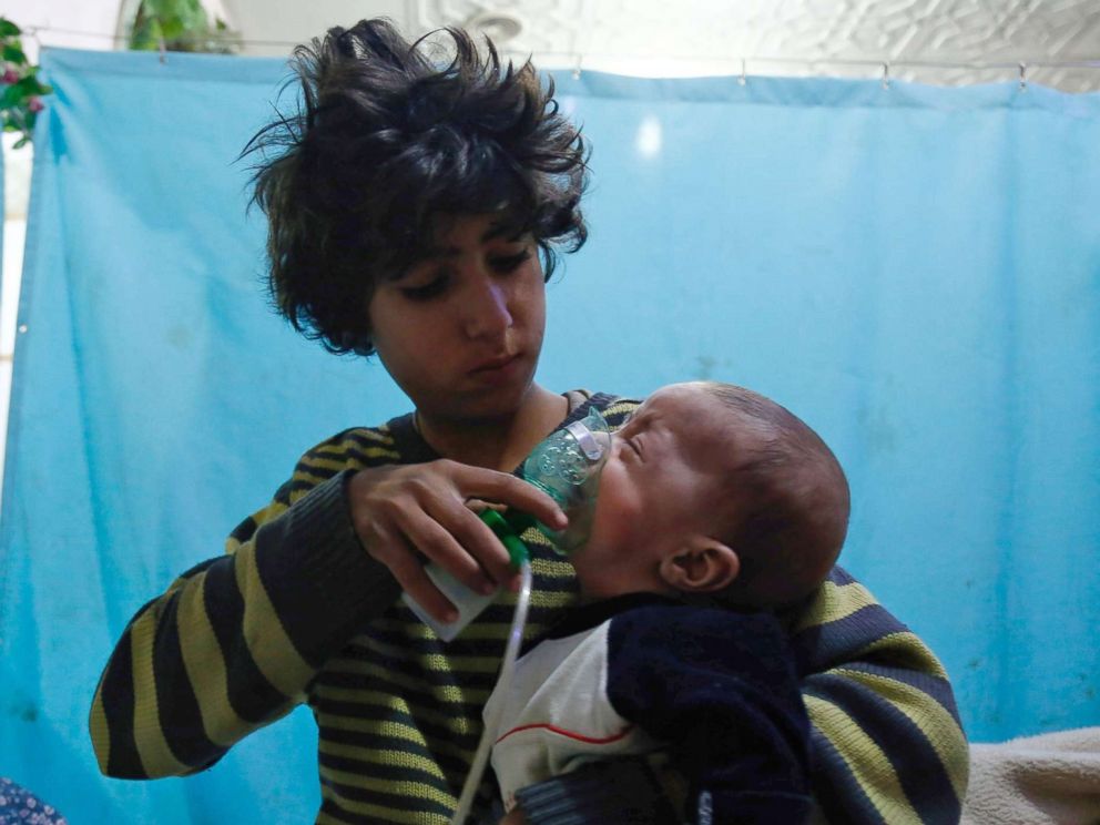 PHOTO: A Syrian boy holds an oxygen mask over the face of an infant at a makeshift hospital following a reported gas attack on the rebel-held besieged town of Douma in the eastern Ghouta region on the outskirts of the capital Damascus on Jan. 22, 2018.