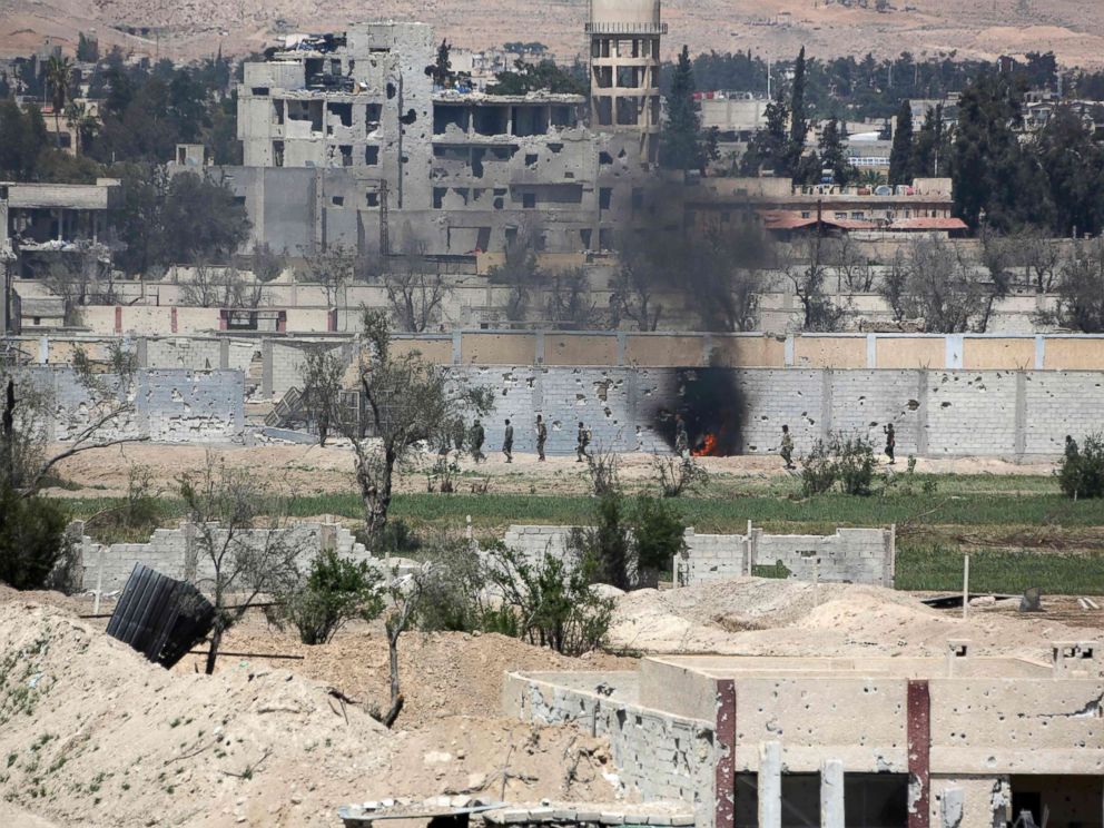 PHOTO: A picture taken on April 8, 2018, shows smoke billowing as Syrian Army soldiers advance in agricultural land on the eastern outskirts of Douma, as they continue their fierce offensive to retake the last opposition holdout in Eastern Ghouta.