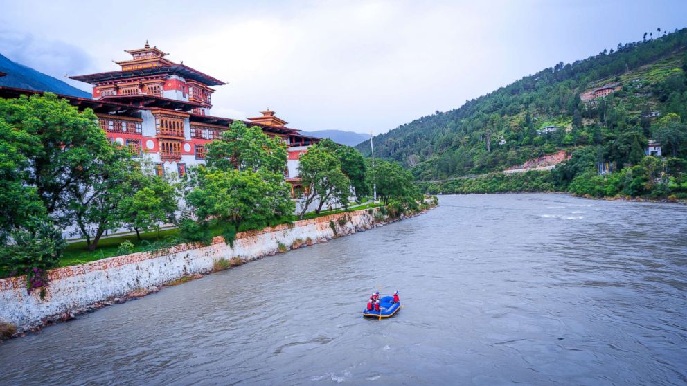 PHOTO: A waterway patrol passes by the Punakha Dzong, which was constructed in 1638, at the convergence of the Pho Chhu (father) and Mo Chhu (mother) rivers.