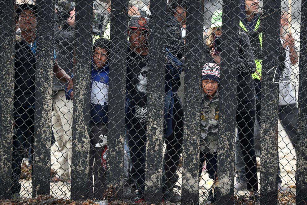 PHOTO: Members of a migrant caravan from Central America and their supporters look through the U.S.-Mexico border wall at Border Field State Park before making an asylum request, in San Diego, Calif., April 29, 2018.