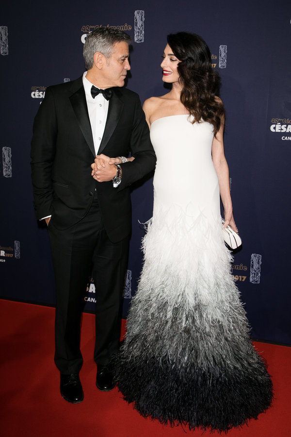 Amal Clooney, pictured with husband George Clooney, wore a gradient feathered Versace gown for the C&eacute;sar Film Awards c