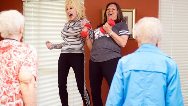 Country music superstar Dolly Parton, center left, joins in an exercise class at the renamed My People Senior Activity Center in Sevierville, Tenn., Monday, May 7, 2018. Parton came for a dedication ceremony Monday to rename the facility in honor of her parents, Robert and Avie Lee Parton. (Brianna Paciorka/Knoxville News Sentinel via AP)