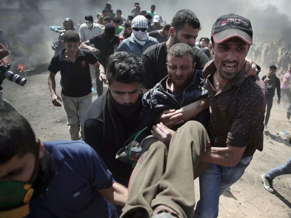 PHOTO: Palestinian protesters carry an injured man who was shot by Israeli troops during a protest at the Gaza Strips border with Israel, May 14, 2018.