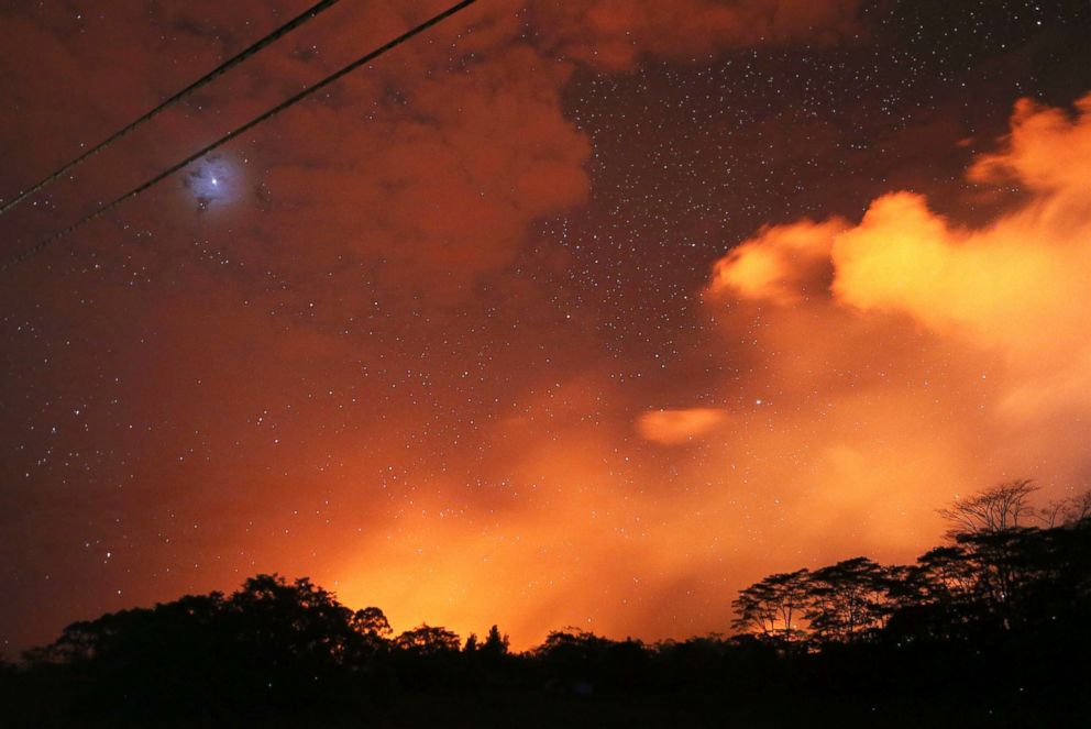 PHOTO: Lava from active fissures illuminates volcanic gases from the Kilauea volcano as stars shine on Hawaiis Big Island, May 15, 2018, in Hawaii Volcanoes National Park, Hawaii.