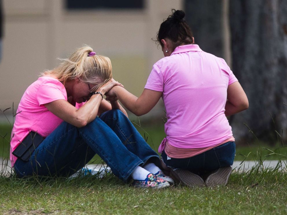PHOTO: Two women pray outside the family reunification site following a shooting at Santa Fe High School on May 18, 2018, in Santa Fe, Texas.