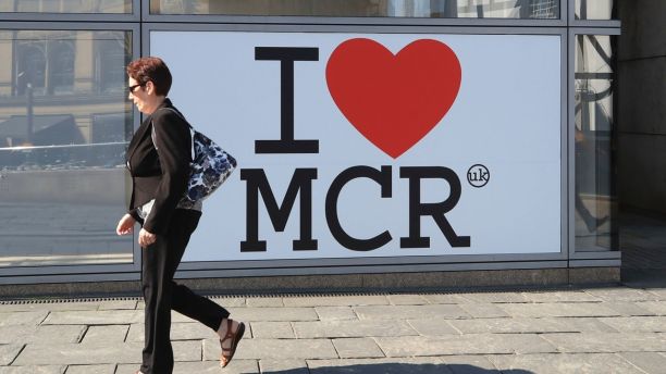 A woman walks past a 'I Love Manchester' sign ahead of the Manchester Arena National Service of Commemoration at Manchester Cathedral to mark one year since the attack on Manchester Arena, Tuesday May 22, 2018. (Peter Byrne/PA via AP)