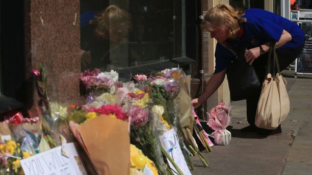 A woman leaves some flowers in Manchester, England ahead of the Manchester Arena National Service of Commemoration at Manchester Cathedral to mark one year since the attack on Manchester Arena, Tuesday May 22, 2018. (Peter Byrne/PA via AP)