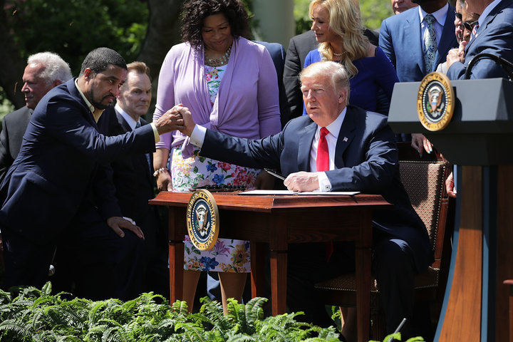 Pastor Darrell Scott and President Donald Trump shake hands at the the National Day of Prayer ceremony in the White House Ros