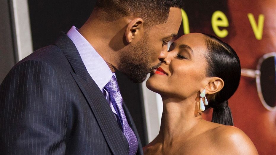 Cast member Will Smith and his wife Jada Pinkett Smith kiss at the premiere of "Focus" at the TCL Chinese theatre in Hollywood, California February 24, 2015.