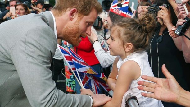 El prÃ­ncipe Enrique, izquierda, saluda a una niÃ±a durante una caminata con el prÃ­ncipe Guillermo para saludar a una multitud fuera del castillo en Windsor, Inglaterra, un dÃ­a antes de la boda de Enrique con Meghan Markle el viernes 18 de mayo de 2018. (Ben Birchall/PA via AP)