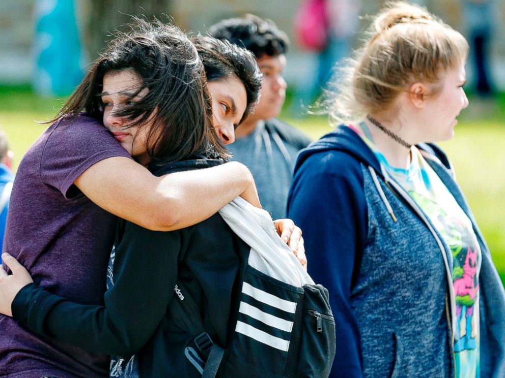 PHOTO: Santa Fe High School freshman Caitlyn Girouard, center, hugs her friend outside the Alamo Gym where students and parents wait to reunite following a shooting at Santa Fe High School, May 18, 2018, in Santa Fe, Texas.