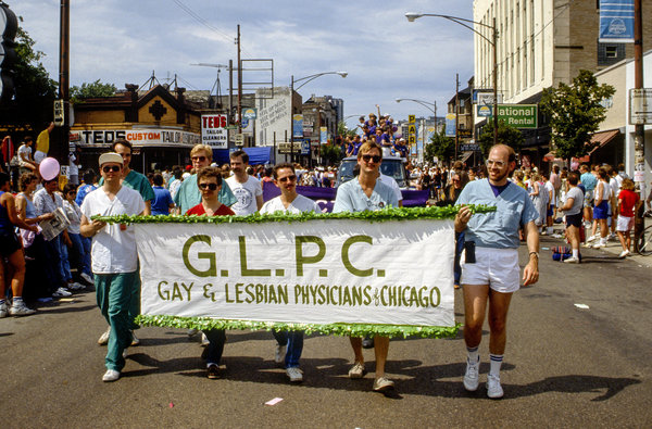 Near the intersection of North Broadway and West Barry Avenue, participants march behind a banner that reads 'G.L.P.C., Gay &