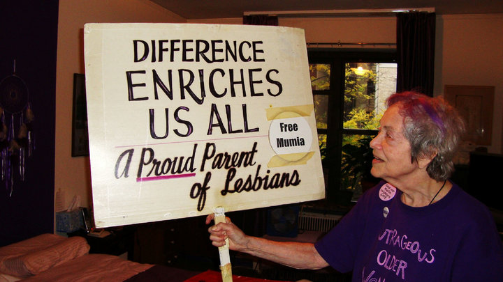 Frances Goldin shows the other side of her sign.