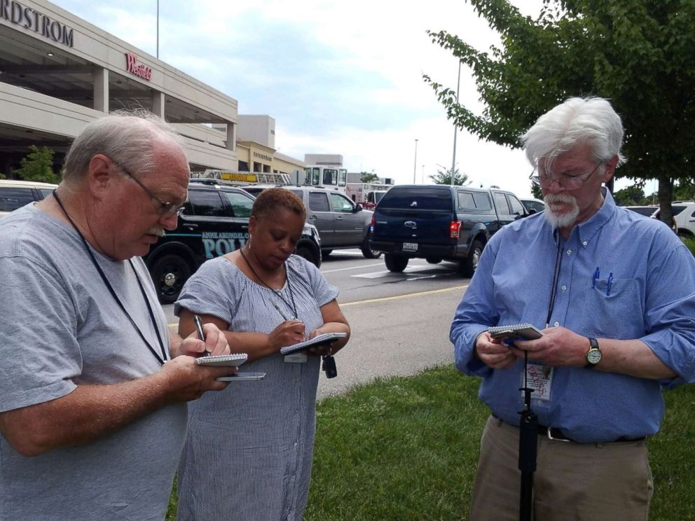 PHOTO: Capital Gazette journalist E.B. Pat Furgurson III takes notes with two other people as police officers respond to a shooting inside Capital Gazette offices in Annapolis, Md., June 28, 2018.