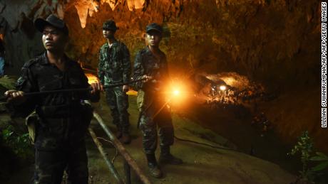 Thai soldiers relay electric cable deep into the entrance of the Tham Luang Nang Non cave network.