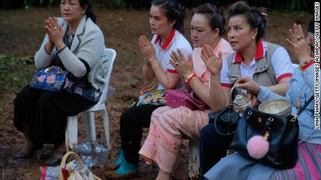 Buddhist followers pray at the entrance of Tham Luang Nang Non caves in the hope of finding the boys alive.