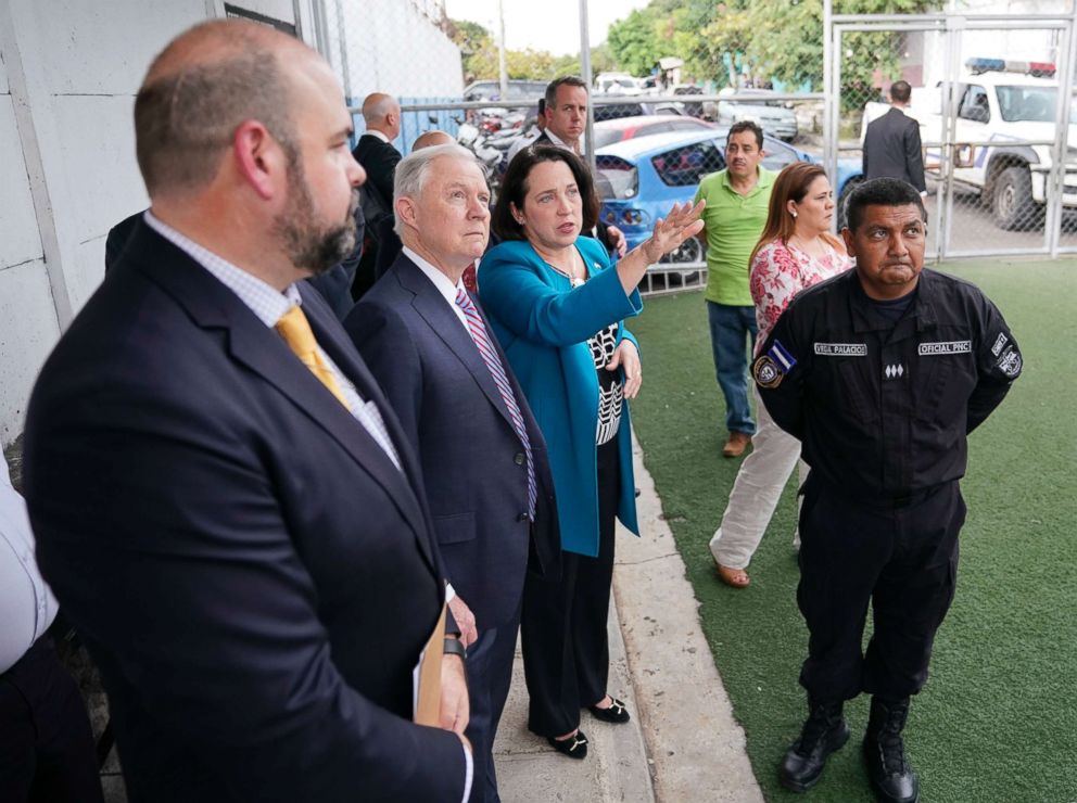 PHOTO: U.S. Attorney General Jeff Sessions, center, and U.S. Ambassador to El Salvador Jean Elizabeth Manes, right, stop to look across the courtyard during a tour of local police station and detention center in San Salvador, El Salvador, July 27, 2017.