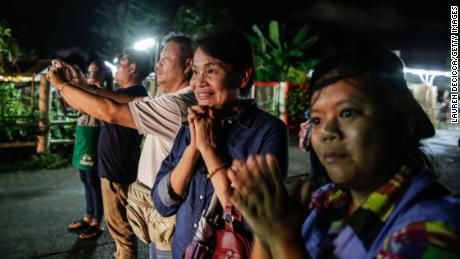 Onlookers watch and cheer as ambulances deliver boys rescued from a cave in northern Thailand to hospital in Chiang Rai, Thailand, after they were transpored by helicopter on July 8, 2018.
