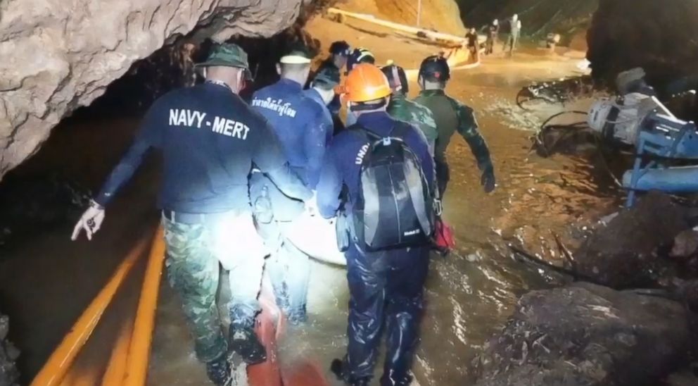 PHOTO: A group of rescuers tote a stretcher containing one of the boys through a muddy and watery stretch as they head to the mouth of the cave on foot. 