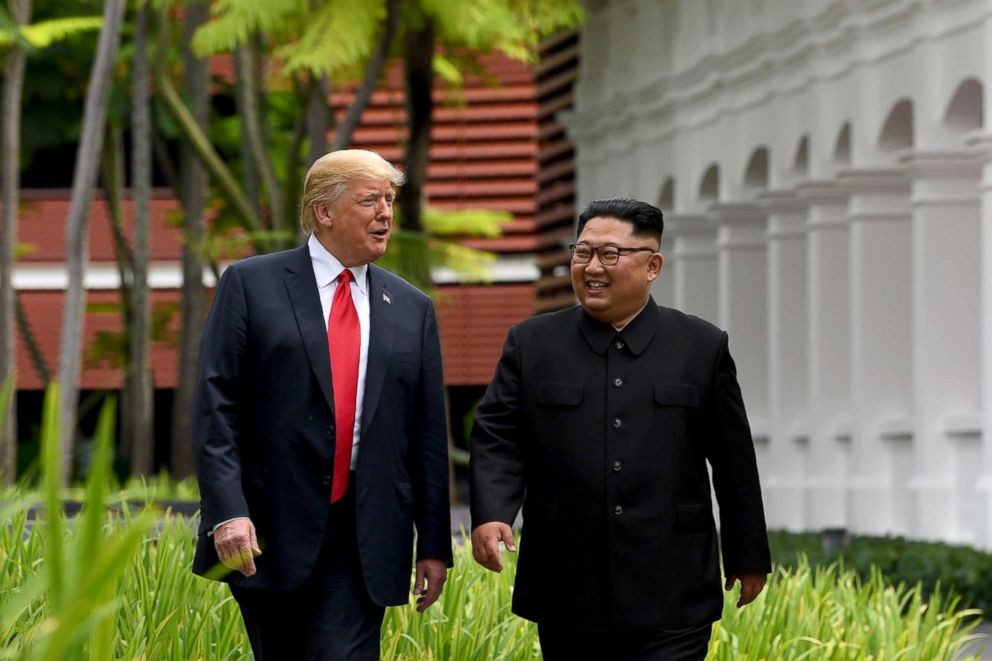 PHOTO: North Koreas leader Kim Jong Un walks with President Donald Trump, left, during a break in talks at their historic US-North Korea summit at the Capella Hotel on Sentosa island in Singapore, June 12, 2018.