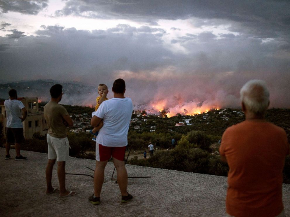 PHOTO: People watch a wildfire in the town of Rafina, near Athens, Greece, July 23, 2018.