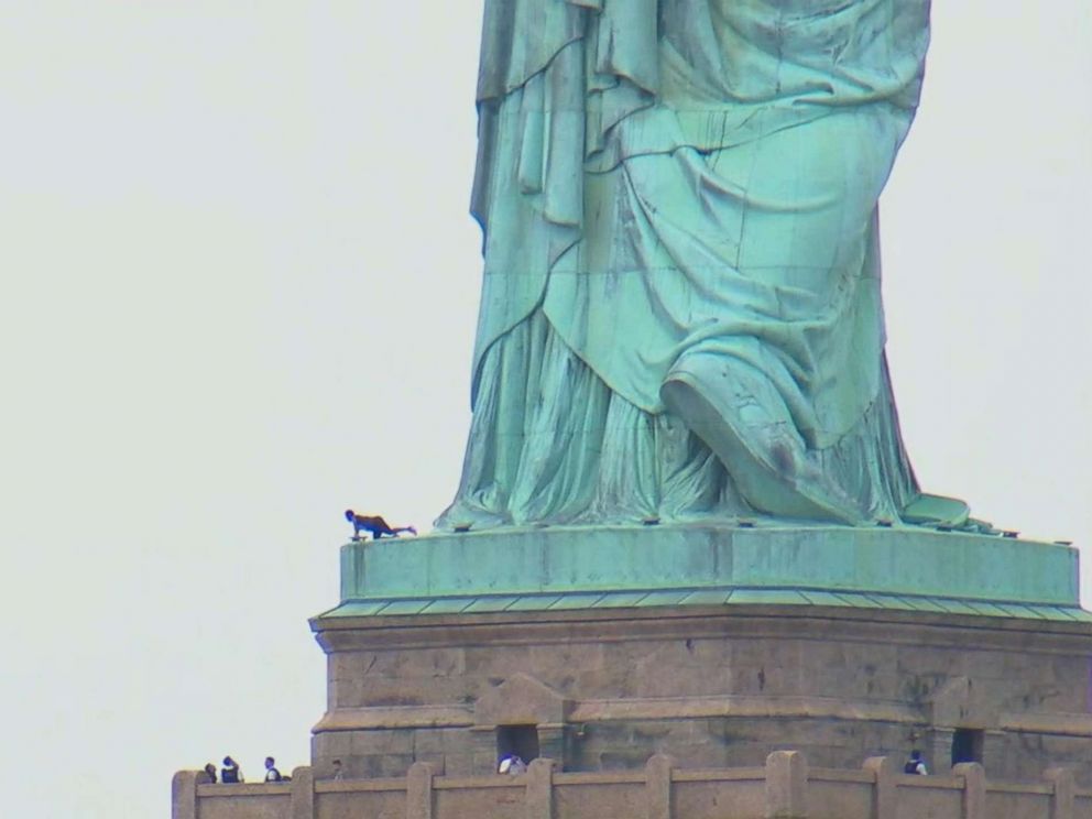 PHOTO: A woman appears to be climbing up the Statue of Liberty, July 4, 2018 in New York.