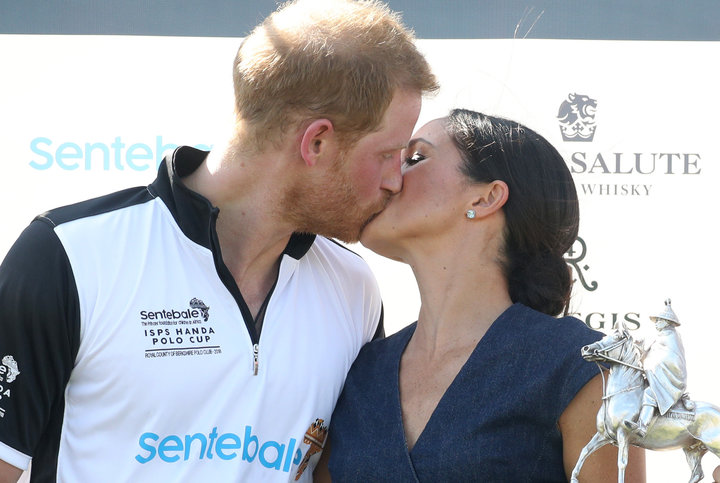 Meghan, Duchess of Sussex and Prince Harry kiss after posing with the trophy after the Sentebale Polo Cup&nbsp;on July 26 in 