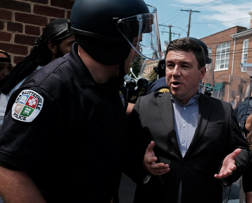 Unite The Right rally organizer Jason Kessler is escorted by police after he attempted to speak at a press conference in fron