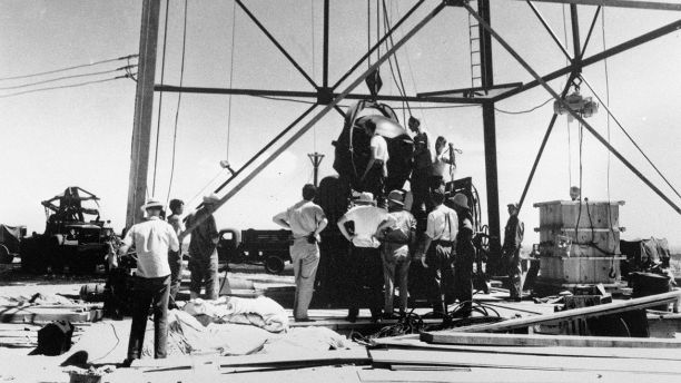 FILE - In this July 6, 1945, file photo, scientists and workmen rig the world's first atomic bomb to raise it up onto a 100 foot tower at the Trinity bomb test site near Alamagordo, N.M. The National Cancer Institute said its long-anticipated study into the cancer risks of New Mexico residents living near the site of the world's first atomic bomb test likely will be published in 2019. Institute spokesman Michael Levin told The Associated Press that researchers are examining data on diet and radiation exposure and expect to finish the study by early next year. (AP Photo/File)