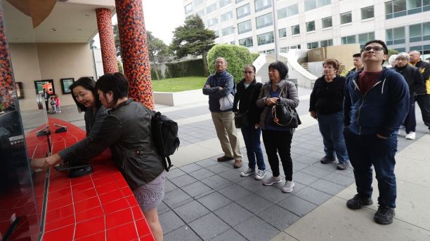 In this Thursday, Aug. 23, 2018 photo, a woman who did not give her name, second from left, buys tickets for the movie Crazy Rich Asians for her and her aunt at a movie theater in Daly City, Calif. When "Crazy Rich Asians" surpassed expectations and grabbed the top spot in its opening weekend, the film also pulled off another surprising feat. It put Asians of a certain age in theater seats. (AP Photo/Jeff Chiu)