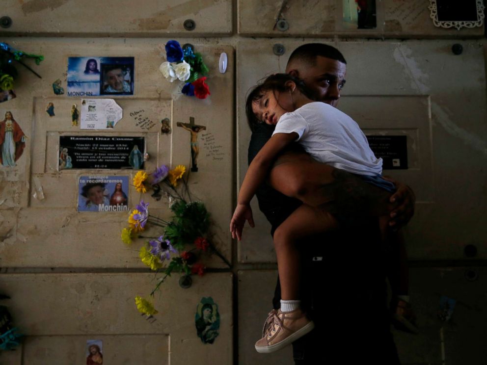 PHOTO: Orlando Gonzalez holds his daughter during the funeral of their neighbor Victor Ruiz Ramos in Corozal, Puerto Rico, Oct. 02, 2017. Ruiz died after he no longer able to power a machine that treated his emphysema.