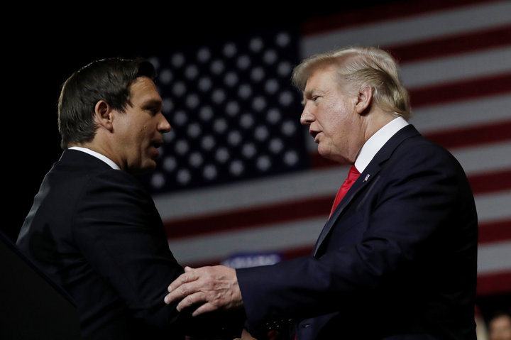 President Donald Trump talks with Ron DeSantis during a Make America Great Again Rally at the Florida State Fairgrounds in Ta