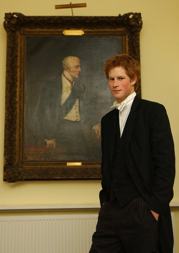 Prince Harry, wearing a school uniform, poses by a portrait of the Duke of Wellington at the Manor House, Eton College, on Ma