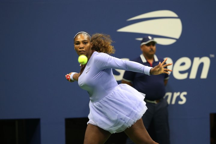 Serena Williams, rocking a lavender tutu, is about to smash a forehand in her second-round match.