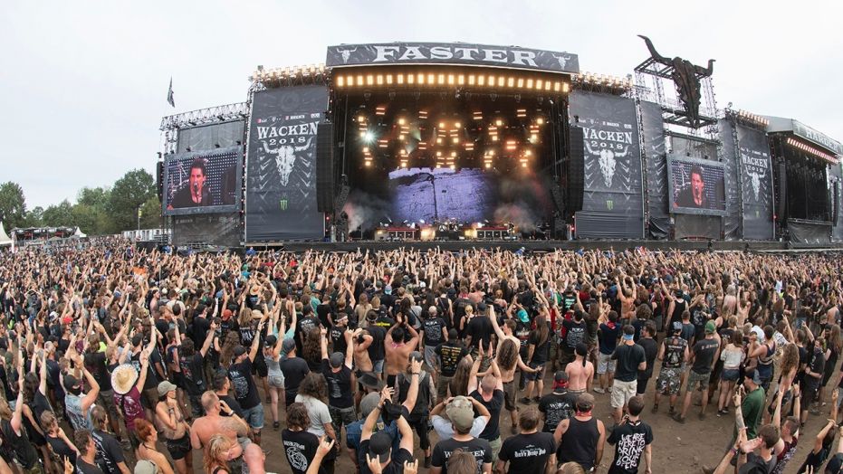 In this Aug. 4, 2018 photo numerous festival goes stand in front of the main stage of the heavy metal festival in Sacken, northern Germany.