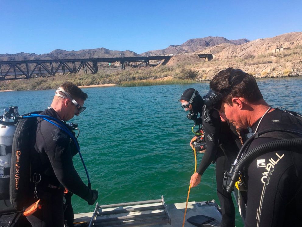 In this photo released by Los Angeles Sheriff Department Special Enforcement Bureau their dive team assists San Bernardino County Sheriffs in the search for three missing persons in the Colorado river Monday, Sept. 3, 2018, near Topock, Ariz.