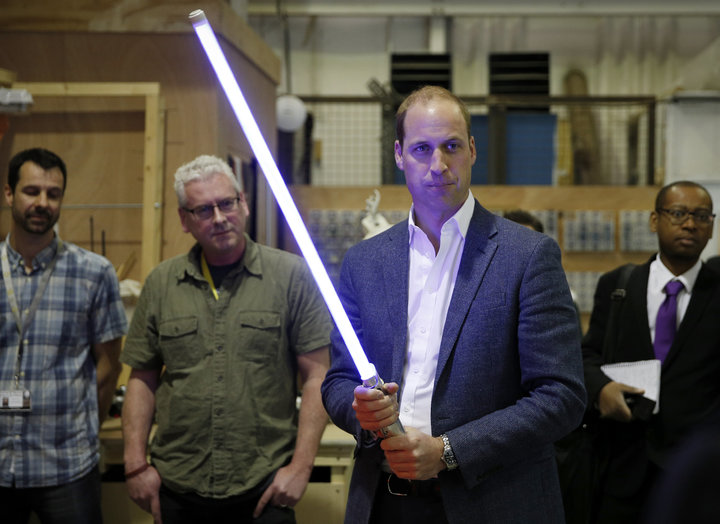 Prince William holds a lightsaber during a visit to the Star Wars film set at Pinewood Studios near Iver Heath, west of Londo