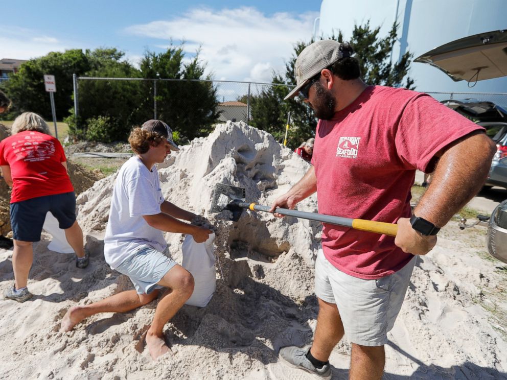 PHOTO: Walker Townsend, at right, from the Isle of Palms, S.C., fills a sand bag while Dalton Trout, in center, holds the bag at the Isle of Palms municipal lot in preparation for Hurricane Florence at the Isle of Palms S.C., Monday, Sept. 10, 2018.