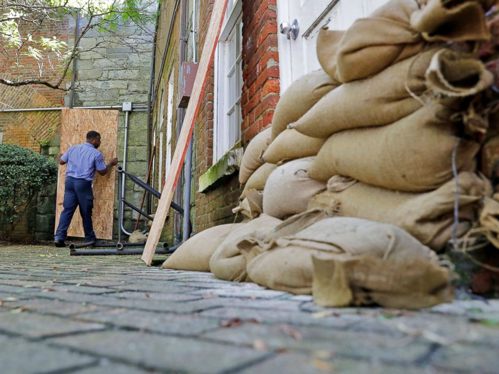 PHOTO: Brandon Alston carries a board to be placed over a window of the Casemate Museum on Fort Monroe, Tuesday, Sept. 11, 2018, in Hampton, Va. The staff is preparing for rising waters and other possible flooding due to Hurricane Florence.