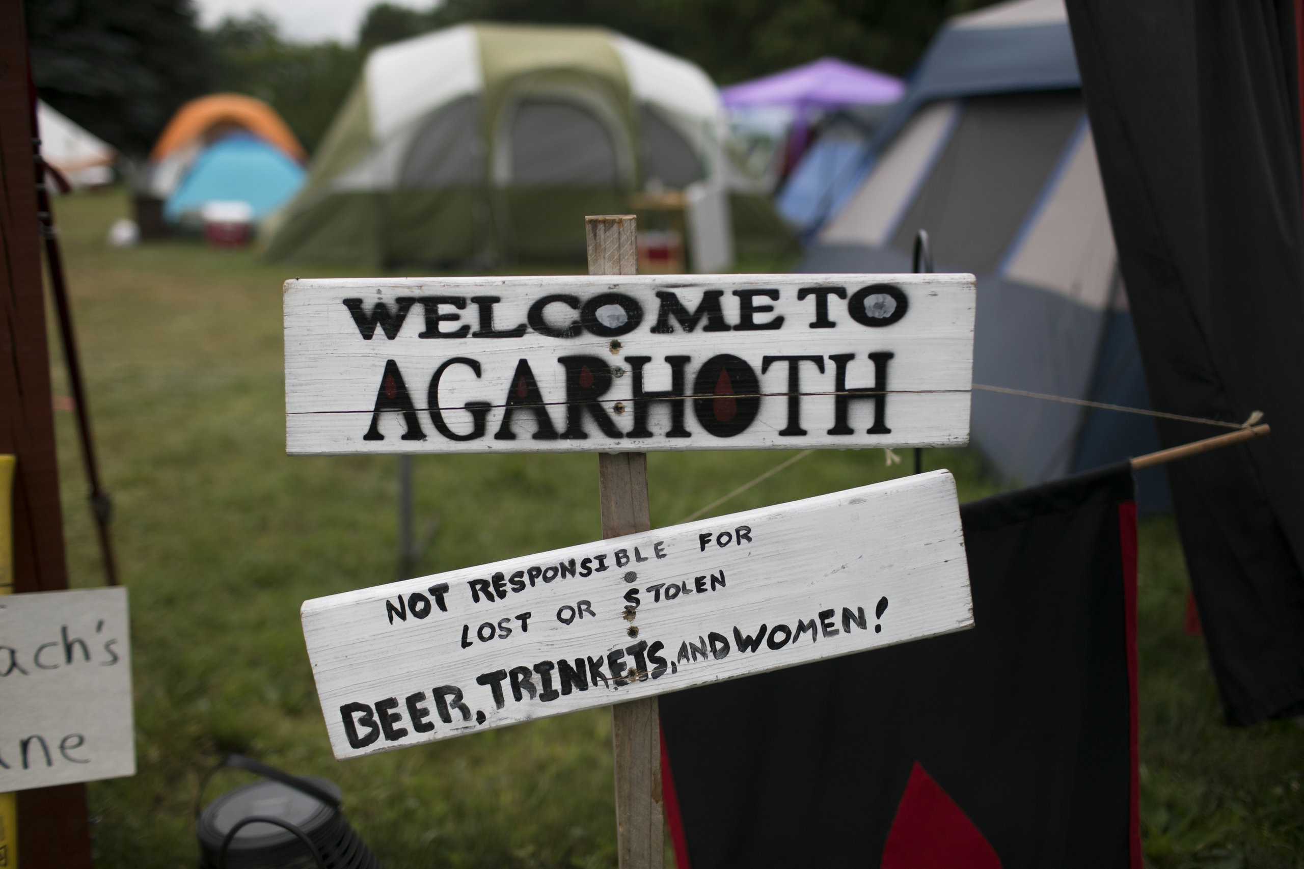 A "Welcome to Agarhoth" sign at a camp entrance.