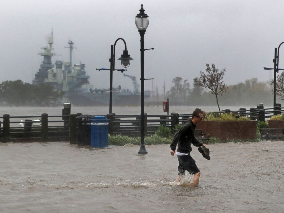 PHOTO: A man crosses a flooded street in downtown Wilmington, N.C., after Hurricane Florence made landfall Friday, Sept. 14, 2018.