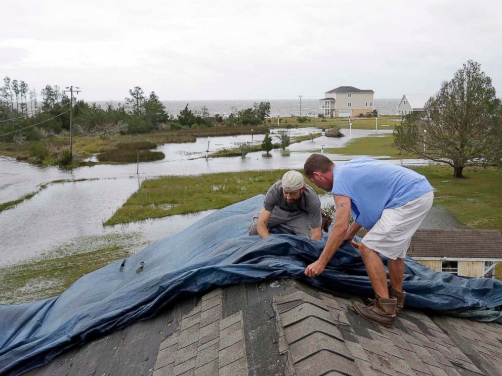 Jeff Pyron, left, and Daniel Lilly cover Lillys roof after Hurricane Florence hit Davis N.C., Saturday, Sept. 15, 2018. The town had 4 1/2 feet of storm surge. 