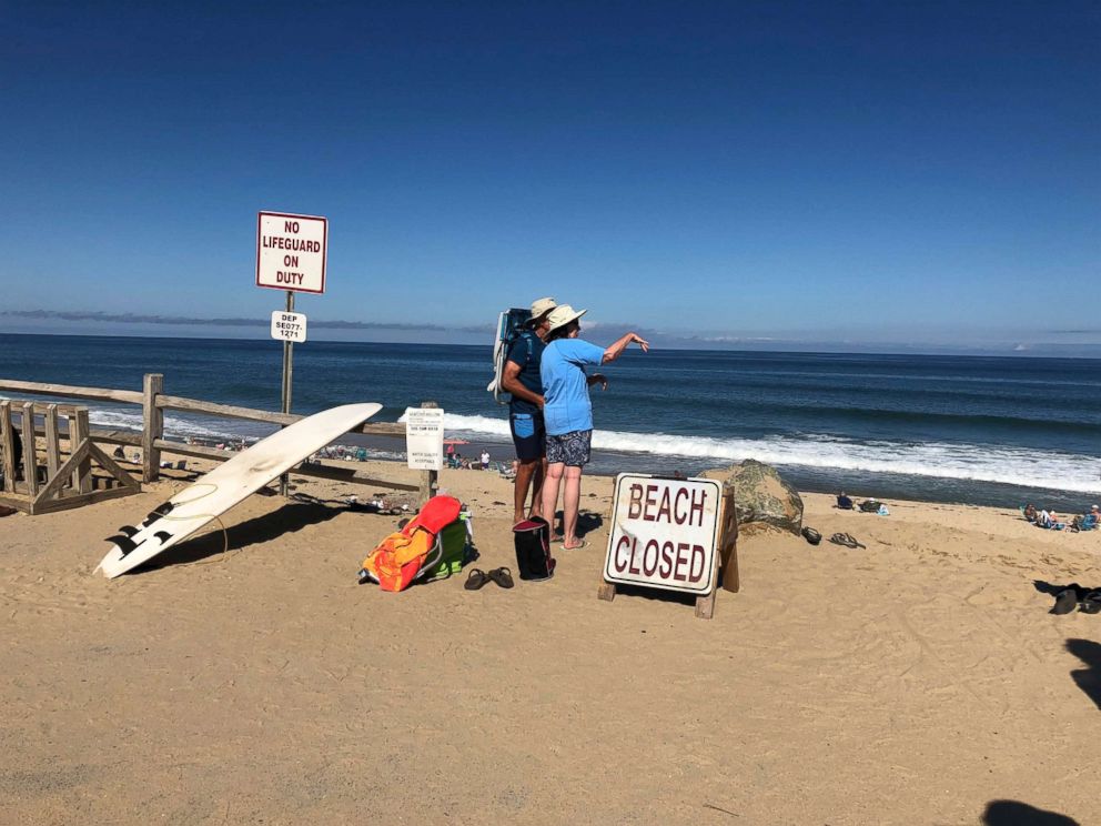 PHOTO: Two people look out at the shore after a reported shark attack at Newcomb Hollow Beach in Wellfleet, Mass., Sept. 15, 2018.