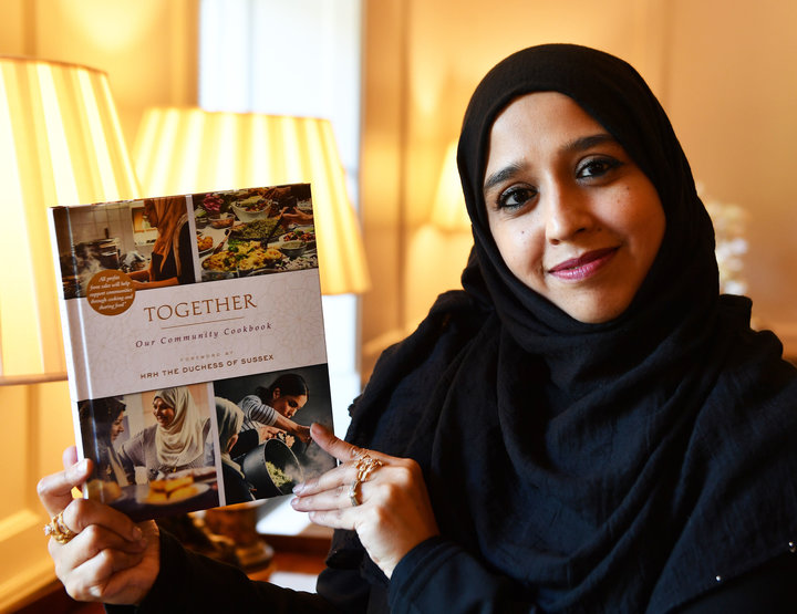 Zahira Ghaswala at Kensington Palace holding a copy of Together, a book that tells how women came together after the Grenfell