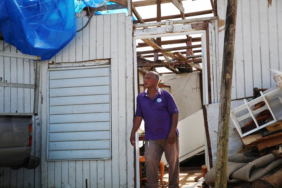 Three weeks after the storm, Danny Guerrero Herrera stands at the door of his home, which was largely destroyed by Hurricane 
