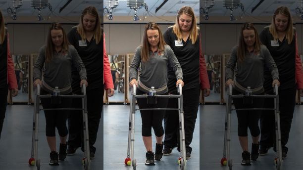 In this May 22, 2018 photo provided by the University of Louisville, Professor Susan Harkema watches as Kelly Thomas of Lecanto, Fla., practices walking with the help of a walker. "Recovery can happen if you have the right circumstances," says Harkema, who co-authored a report on the use of electrical implants to stimulate the spinal cord. (Tom Fougerousse/University of Louisville via AP)