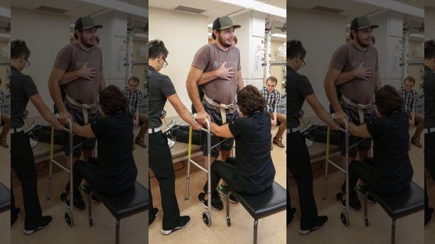 Jered Chinnock stands with the assistance of his therapy team at the Mayo Clinic in Rochester, Minn., on Sept. 18, 2018. Chinnock, paralyzed since 2013, can stand and take steps again thanks to an electrical implant that zaps his injured spine and months of intense rehab as part of a medical study at the clinic. At right is Peter Grahn, PhD, senior engineer. Second from right is doctoral candidate Jonathan Calvert. (AP Photo/Teresa Crawford)